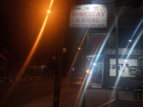 un bâtiment avec un panneau dans une rue la nuit dans l'établissement Homestay Kamal, à Padangpanjang