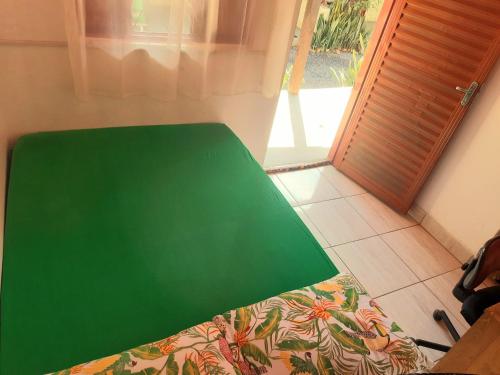 a green table in a room next to a door at Hospedagem Jabuti no Centro de São Jorge in Sao Jorge
