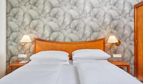 a bedroom with two beds and a wall mural at Hotel Stoiser in Loipersdorf bei Fürstenfeld