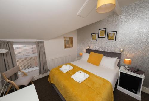 1 dormitorio con 1 cama con 2 toallas en Hermosa Guest House en Scarborough