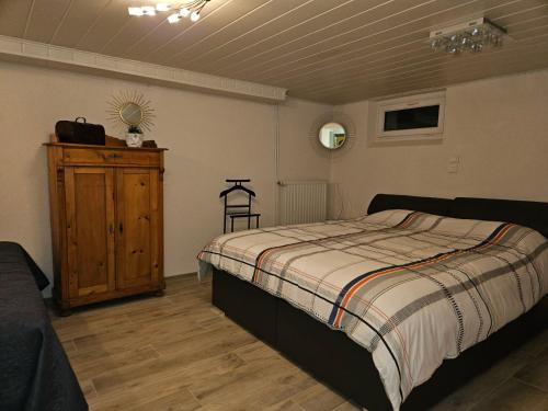 una camera con letto e armadio in legno di Appartement neuf 1 à 6 personnes dans maison individuelle a Haguenau