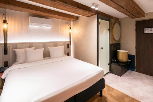a bedroom with a large white bed in a room at Mister Highland Hotel in Amsterdam