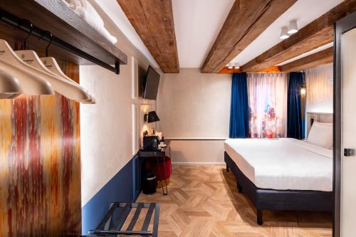 a bedroom with a bed and a bench in a room at Mister Highland Hotel in Amsterdam