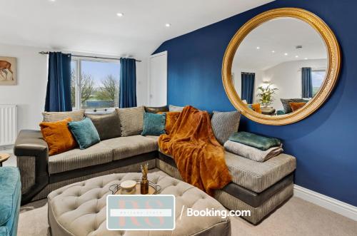 ein Wohnzimmer mit einem Sofa und einem Spiegel in der Unterkunft Two Bedroom Apartment By Rutland Stays Short Lets & Serviced Accommodation With Parking in Oakham