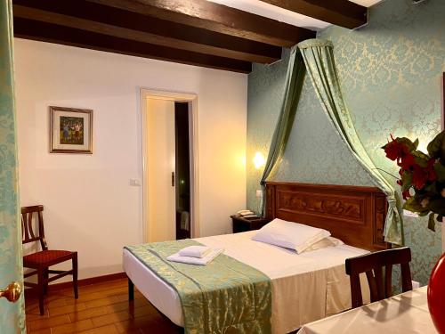 - une chambre avec un lit, une table et des chaises dans l'établissement Hotel Canada, à Venise