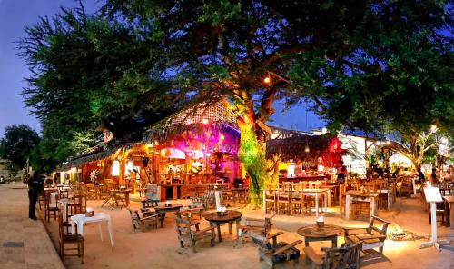 um restaurante com mesas e cadeiras em frente a uma árvore em Pousada Jeri em Jericoacoara