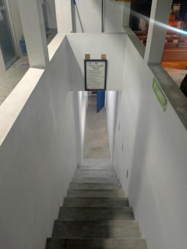 un escalier dans un bâtiment muni d'un panneau. dans l'établissement Homestay Kamal, à Padangpanjang