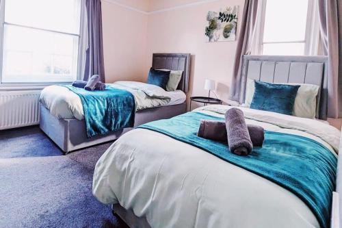 1 dormitorio con 2 camas y toallas. en Spacious & Budget Friendly 5 Bed Home! en Maidenhead