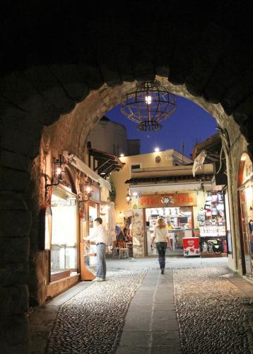 a group of people walking down a street at night at Mediterranean Hotel in Rhodes Town