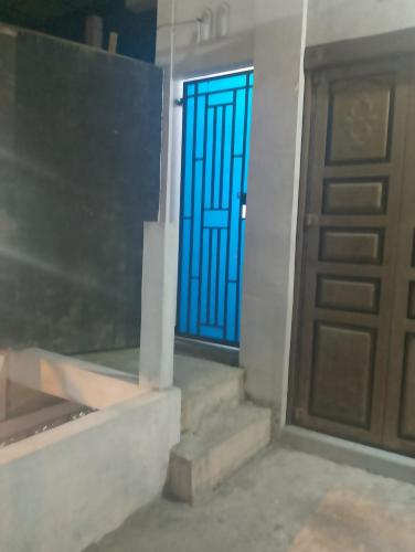 drzwi do pokoju ze schodami i niebieskimi drzwiami w obiekcie Homestay Kamal w mieście Padangpanjang