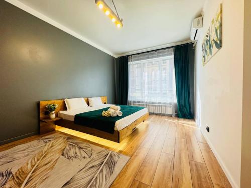 um quarto com uma cama e uma janela em Infinity Estate Atameken em Almaty