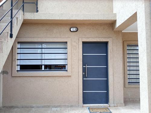 a blue door on the side of a house at Atenea in Chivilcoy