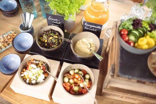 a table topped with bowls of different types of food at Magni Boutique Hotel in Braunschweig