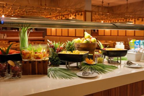 a buffet with fruits and vegetables on a counter at Aqualuz Troia Mar by The Editory in Troia