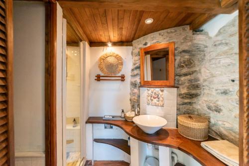 baño con lavabo y pared de piedra en Villa la Finca, en Montferrer