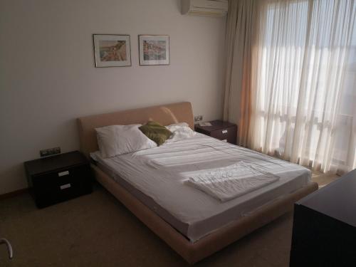 Schlafzimmer mit einem Bett mit weißer Bettwäsche und einem Fenster in der Unterkunft Emerald beach resort and spa , SATIN 705 , Macedonia Street 61, Nesebar Ravda 8238 , in Rawda