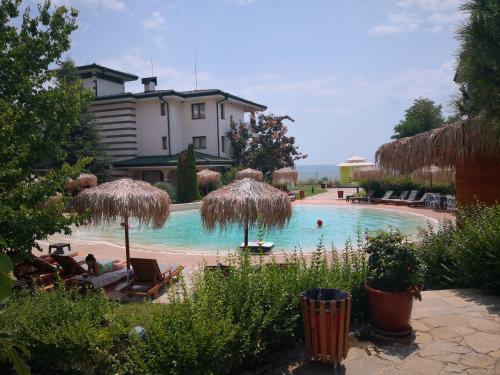 einen Pool mit Stühlen und Sonnenschirmen im Hof in der Unterkunft Emerald beach resort and spa , SATIN 705 , Macedonia Street 61, Nesebar Ravda 8238 , in Rawda