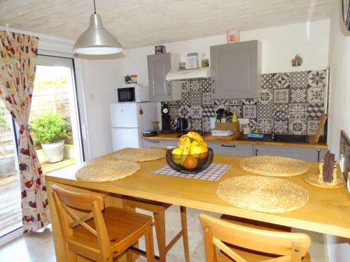 une cuisine avec une table en bois et des chaises ainsi qu'une salle à manger dans l'établissement Le Clos des Lavandes, à Ruffey-lès-Beaune