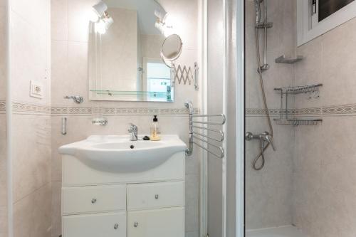 een badkamer met een wastafel, een spiegel en een douche bij Estudio Hércules in Benalmádena