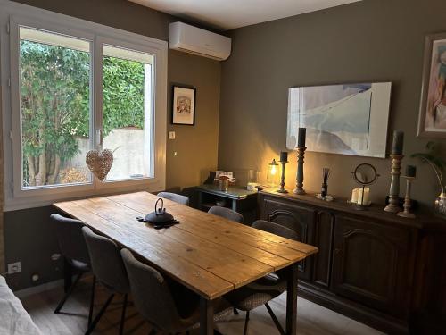 une salle à manger avec une table en bois et une fenêtre dans l'établissement Nid d'Ange en Provence, à Cavaillon