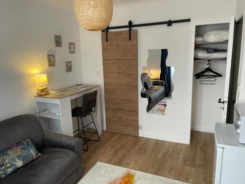 a living room with a couch and a desk and a closet at Chambre Privée chez L' Habitant in Trignac