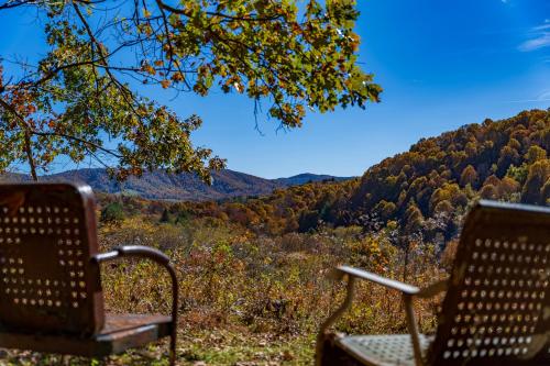 duas cadeiras sentadas no topo de uma colina com árvores em Creekside Paradise - A Peaceful Family Focused Retreat on a Flowing Creek em Sparta