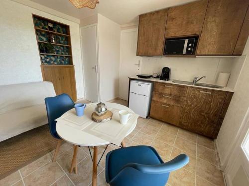une petite cuisine avec une table et des chaises dans une pièce dans l'établissement La Rochelle Rdc de maison proche Ile de Ré, à La Rochelle