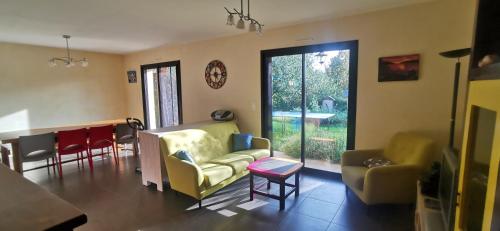 sala de estar con sofá, sillas y mesa en Plain pied au vert, en Oloron-Sainte-Marie