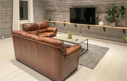 a brown leather couch in a living room with a tv at 3 Bedroom Pet Friendly Apartment In Deje in Deje