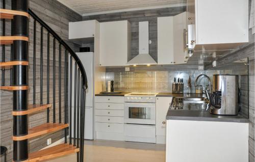 a kitchen with white cabinets and a spiral staircase at 3 Bedroom Pet Friendly Apartment In Deje in Deje