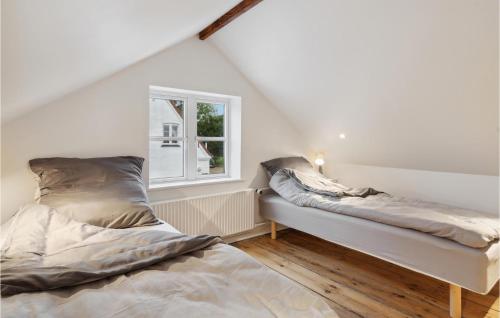 two beds in a room with a window at Lovely Home In Aabenraa With Kitchen in Aabenraa