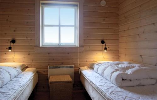 SpodsbjergにあるNice Home In Rudkbing With Wifiのウッドウォールと窓が備わるドミトリールームのベッド2台分です。