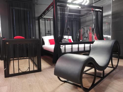 Pokój z łóżkiem, krzesłem i lustrem w obiekcie BDSM Apartament Luxxx gorące serce Częstochowy - ADULTS ONLY w mieście Częstochowa