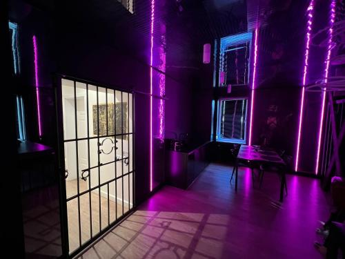 una habitación con luces moradas en las paredes y una puerta en BDSM Apartament Luxxx gorące serce Częstochowy - ADULTS ONLY, en Częstochowa