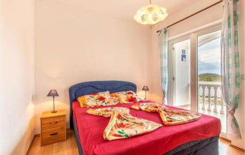 1 dormitorio con 2 camas con sábanas rojas y ventana en Stunning Apartment In Nin With Kitchen, en Nin
