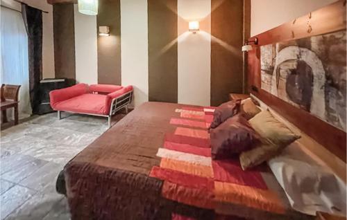 1 dormitorio con 1 cama grande y 1 silla roja en Awesome Home In Vilallonga With Kitchen, en Vilallonga (Villalonga)