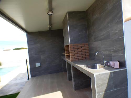 ein Badezimmer mit einem Waschbecken und einer Ziegelwand in der Unterkunft Casa rural Majadales piscina privada alta calidad in Conil de la Frontera