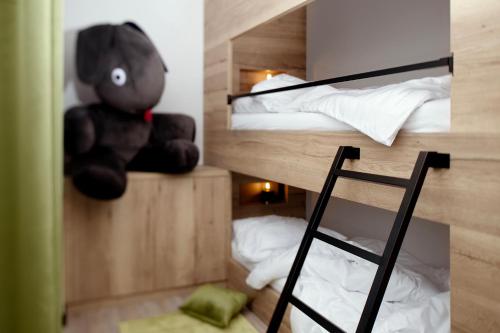 a stuffed teddy bear sitting in a bunk bed at Berg und Tal Hotel & Apartments in Braunlage