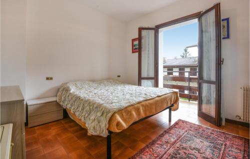 a bedroom with a bed and a large window at Beautiful Apartment In Lusiana Conco With House A Mountain View in Conco