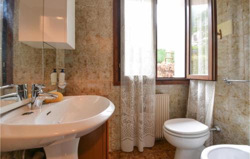 a bathroom with a sink and a toilet and a window at Beautiful Apartment In Lusiana Conco With House A Mountain View in Conco