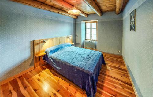 a bedroom with a bed and a wooden floor at Gite Rural Le Couvent in Riom-ès-Montagnes