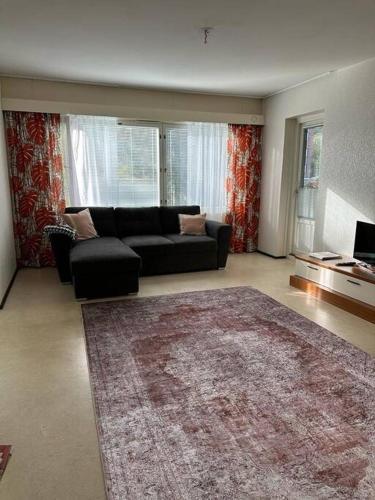 a living room with a couch and a rug at Welcomly apartment MILA in Kotka
