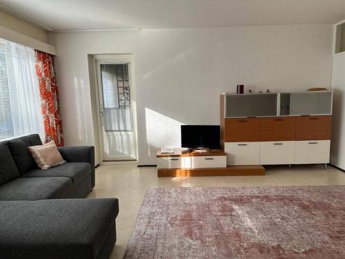 a living room with a couch and a flat screen tv at Welcomly apartment MILA in Kotka