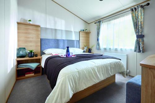 um quarto com uma cama grande e uma janela em Newperran Holiday Park em Newquay