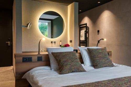 um quarto com uma cama grande e um espelho em Aux Etangs - Hôtel em Battice