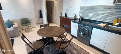a kitchen with a table and a washing machine at Appartement Ilyas in El Jadida