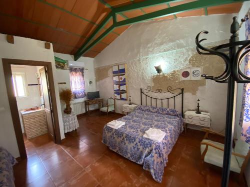 a bedroom with a bed with a blue comforter at Hotel Rural La Cimbarra in Aldeaquemada