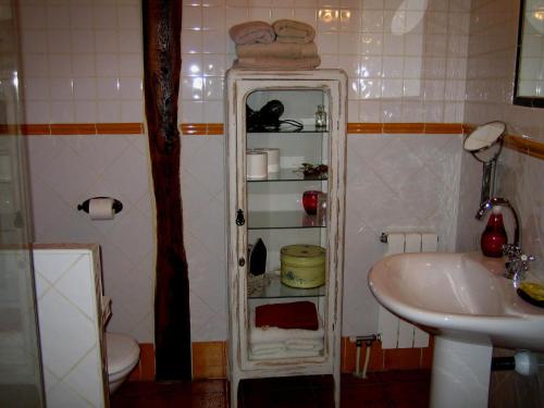 baño pequeño con lavabo y armario blanco en Alojamientos La Herrera en San Esteban de la Sierra
