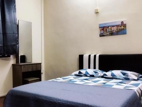 峇都丁宜的住宿－Pinang Beach Home @ Ferringhi，一间卧室配有一张带蓝白色毯子的床