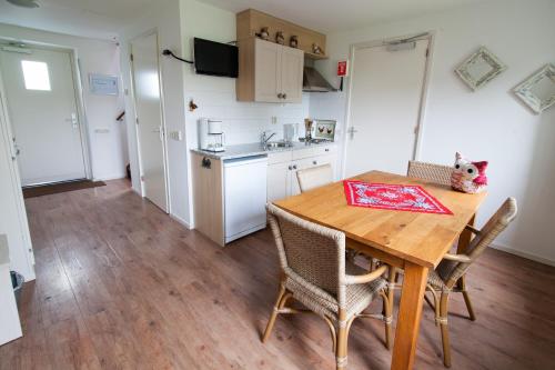 a kitchen and dining room with a wooden table and chairs at Farm Overleekerhoeve in Monnickendam
